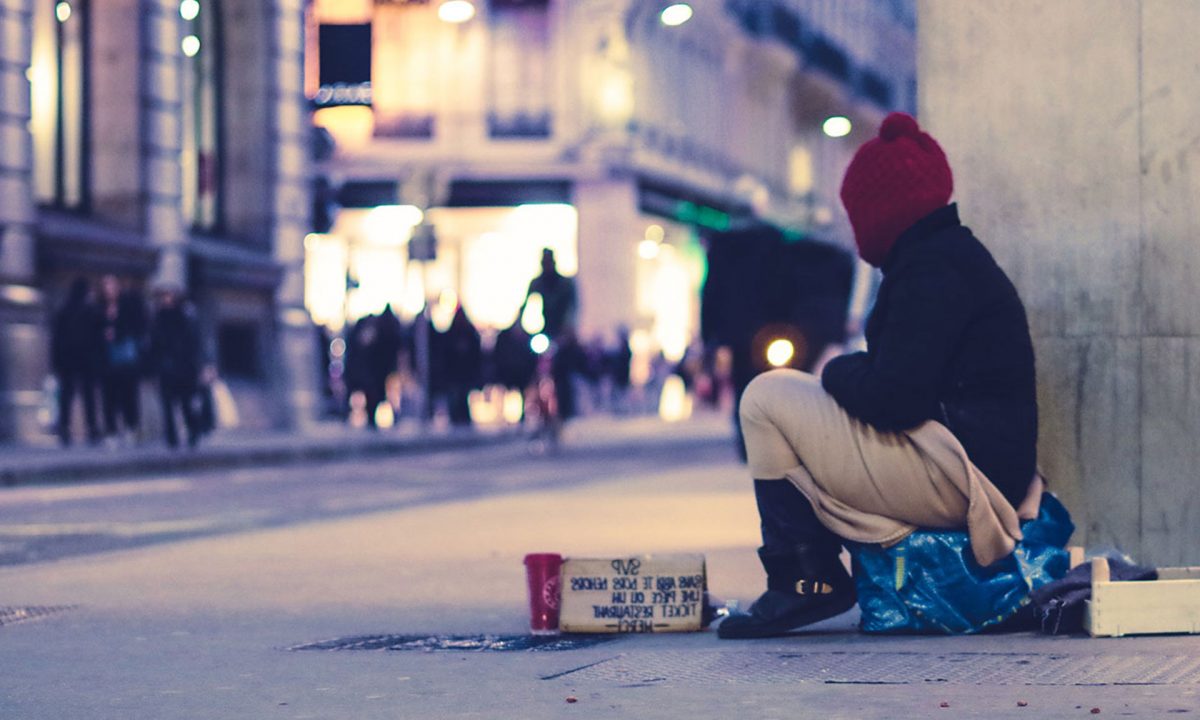senzatetto seduto per strada